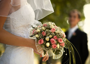 bride in white dress holing bouquet of flowers