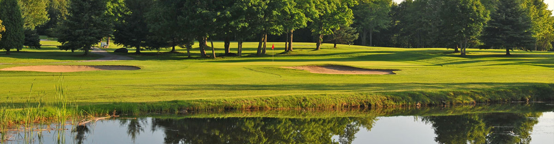 View of greens with a lake in the foreground 